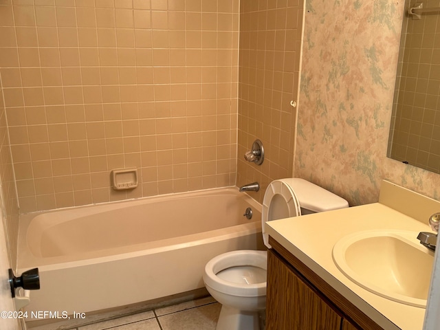 full bathroom with tile patterned flooring, tiled shower / bath, toilet, and vanity