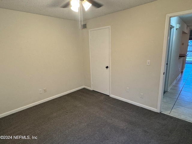 interior space featuring a textured ceiling, ceiling fan, and carpet flooring