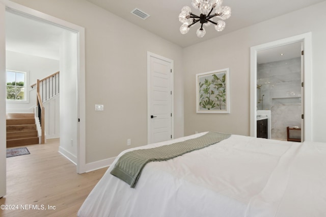 bedroom with baseboards, light wood-style floors, visible vents, and a notable chandelier