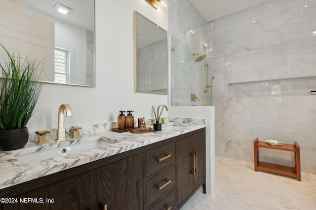 bathroom with a sink, double vanity, and a marble finish shower