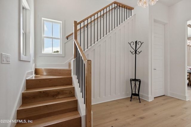 stairway featuring a chandelier and wood-type flooring