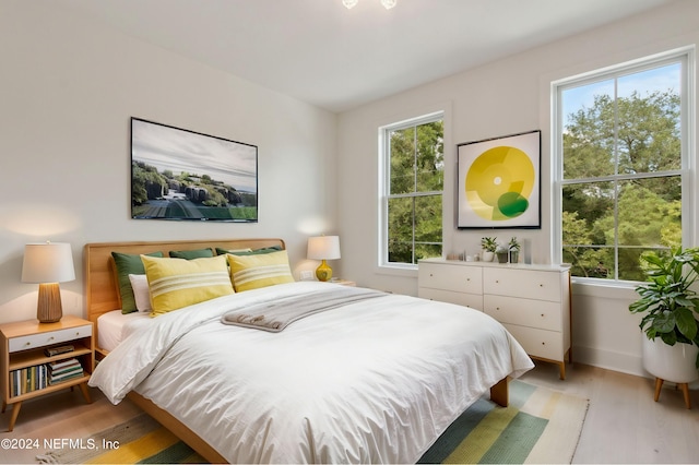 bedroom with multiple windows and light wood-type flooring