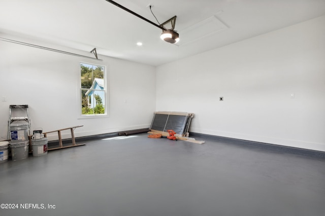 garage with a garage door opener, recessed lighting, and baseboards