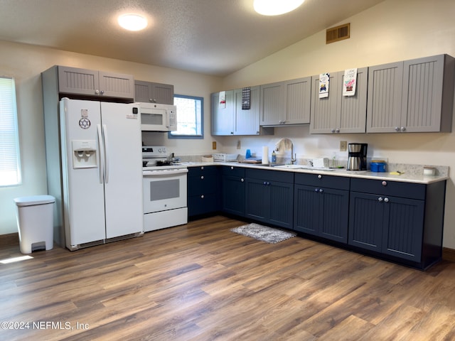 kitchen featuring gray cabinetry, white appliances, wood-type flooring, sink, and lofted ceiling