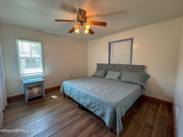 bedroom with ceiling fan, dark hardwood / wood-style flooring, and a textured ceiling