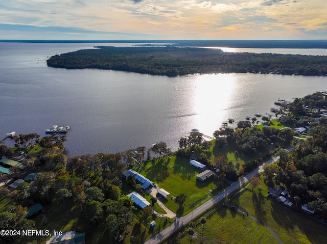 aerial view at dusk featuring a water view