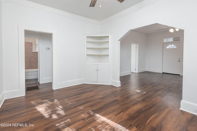 unfurnished living room featuring ornamental molding, dark wood-type flooring, and ceiling fan