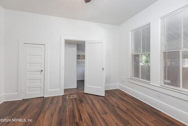 unfurnished bedroom featuring dark wood-type flooring and ceiling fan