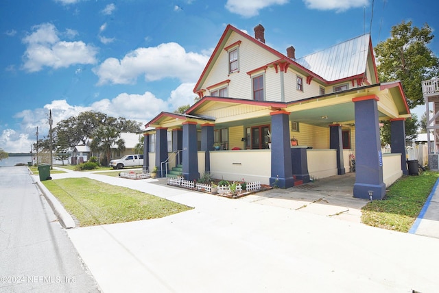 victorian house with a porch and a front yard