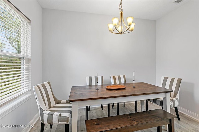 dining room featuring light hardwood / wood-style flooring and a chandelier