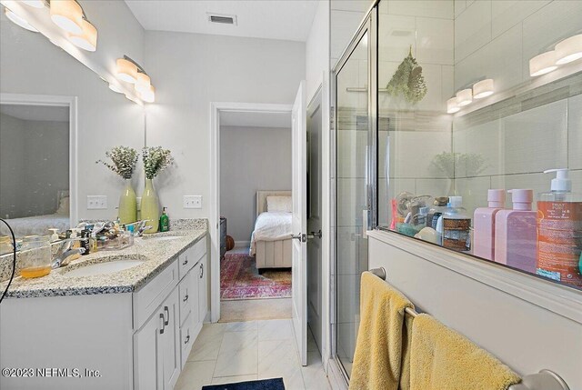 bathroom featuring vanity and a shower with shower door