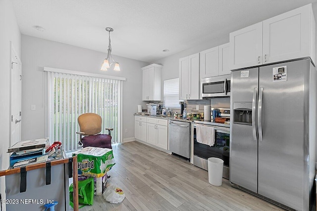 kitchen featuring light hardwood / wood-style flooring, decorative light fixtures, stainless steel appliances, decorative backsplash, and white cabinets