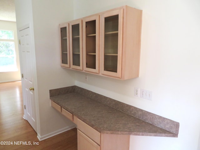 kitchen featuring light brown cabinetry and hardwood / wood-style flooring