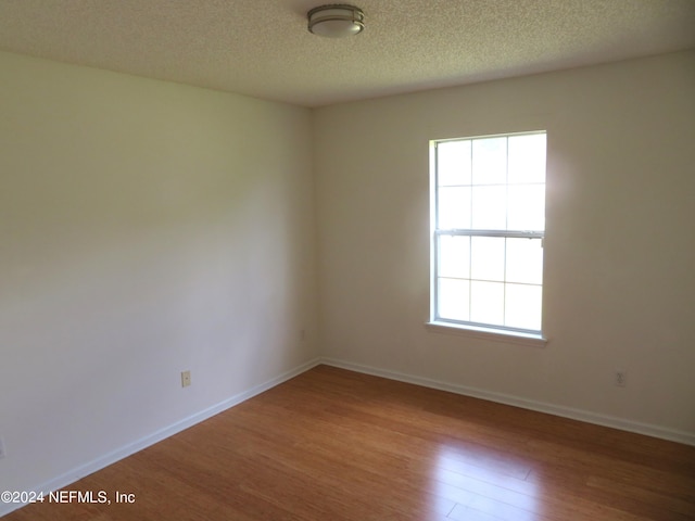 spare room featuring a textured ceiling and hardwood / wood-style floors