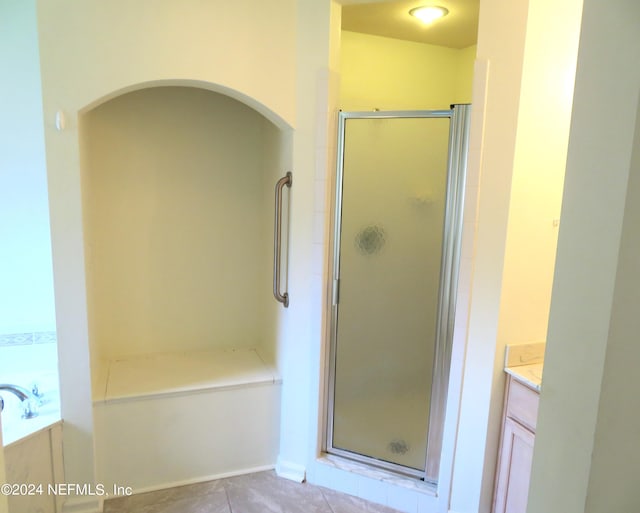 bathroom with tile patterned flooring, vanity, and separate shower and tub