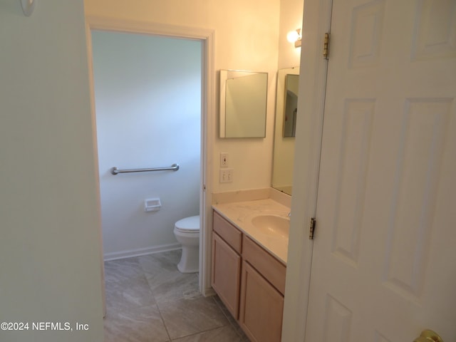 bathroom featuring tile patterned floors, vanity, and toilet