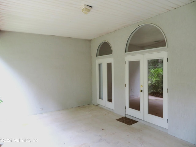 empty room featuring french doors and concrete floors