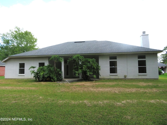 back of property featuring a lawn