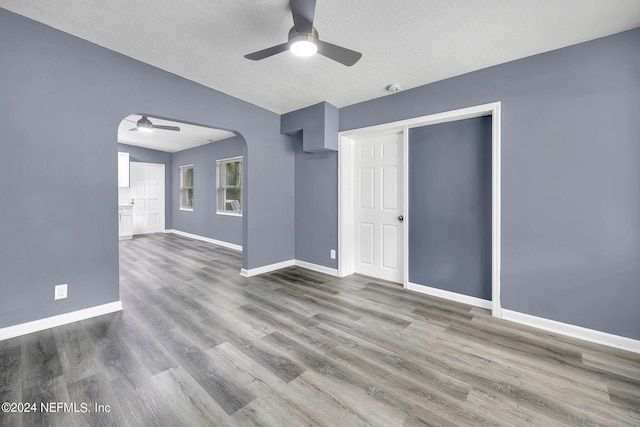 interior space featuring a textured ceiling, ceiling fan, and wood-type flooring