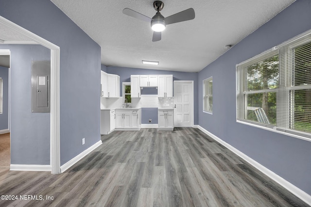 2916 Lippia Rd, Jacksonville, FL 32209 - unfurnished living room featuring wood finished floors, baseboards, a textured ceiling, a ceiling fan, and electric panel
