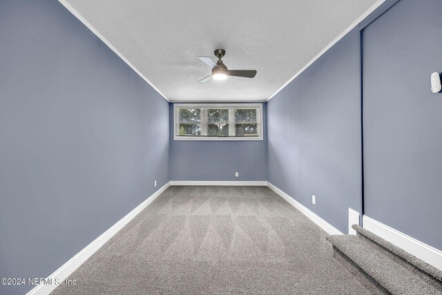 carpeted spare room featuring a textured ceiling and ceiling fan