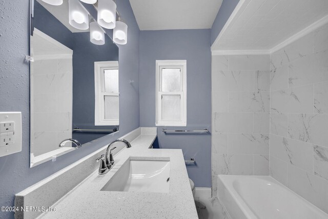 bathroom with tiled shower / bath and vanity