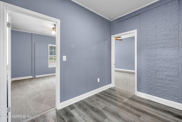 spare room with crown molding, dark wood-type flooring, and ceiling fan