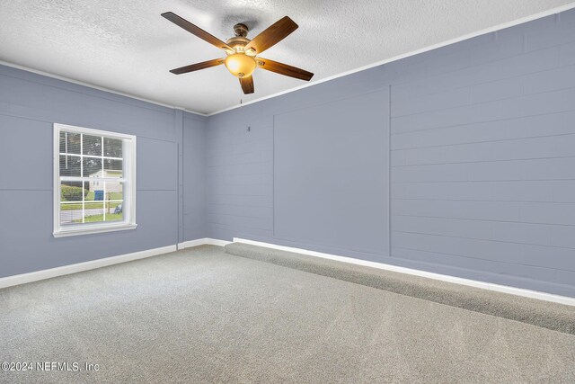 carpeted empty room featuring ceiling fan and a textured ceiling