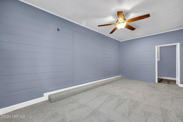 unfurnished room featuring a textured ceiling, carpet flooring, ceiling fan, and crown molding