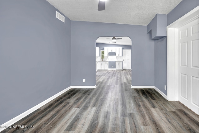 spare room featuring a textured ceiling, dark wood-type flooring, and ceiling fan