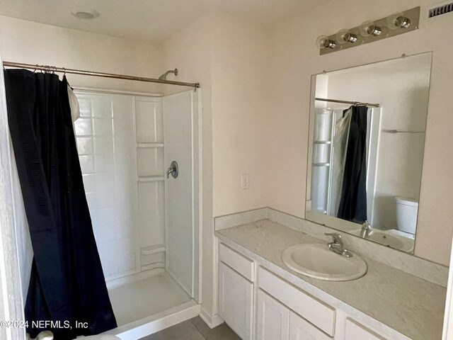 bathroom with vanity, toilet, and walk in shower