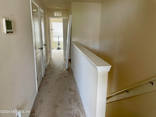 corridor featuring light colored carpet