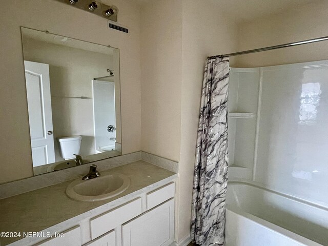 full bathroom featuring shower / bath combination with curtain, toilet, and vanity