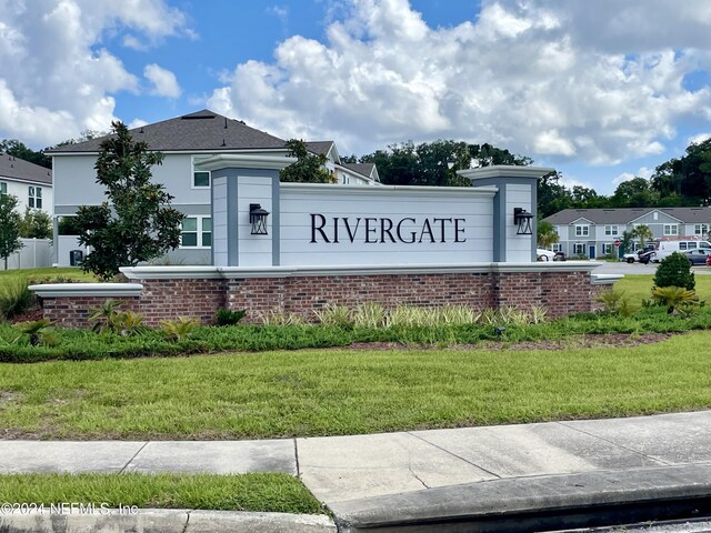 community / neighborhood sign with a yard