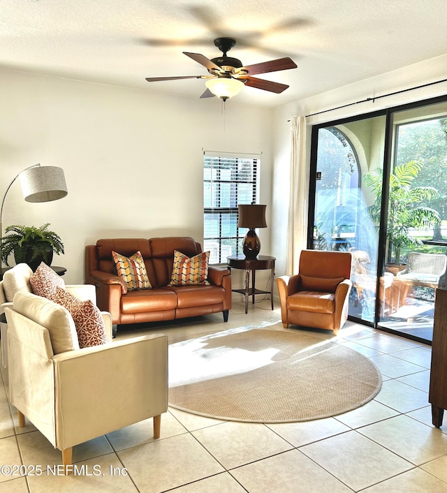 tiled living room featuring ceiling fan and a textured ceiling