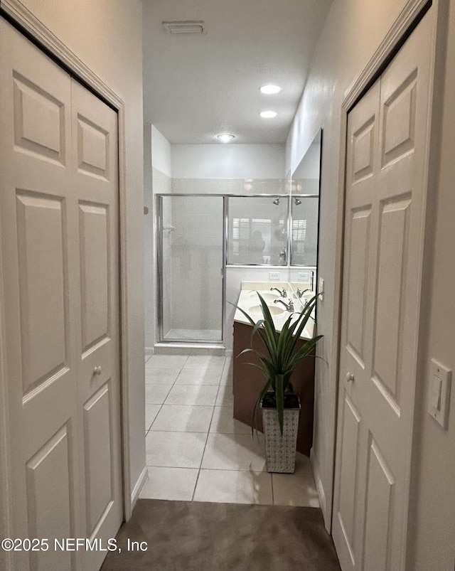 bathroom with tile patterned flooring and a shower with shower door