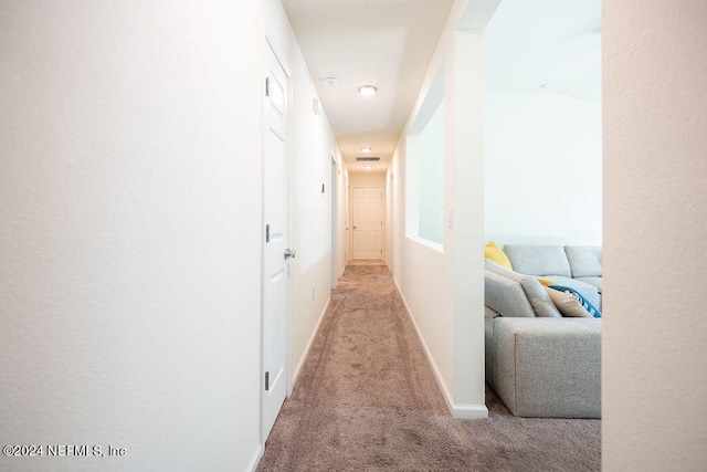 hallway featuring light colored carpet