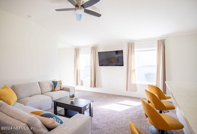 carpeted living room with ceiling fan and vaulted ceiling