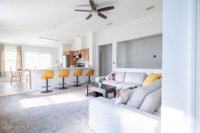 living room featuring light colored carpet and ceiling fan