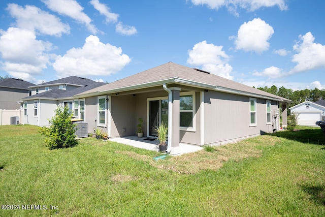 rear view of property with a yard, a garage, and central AC unit