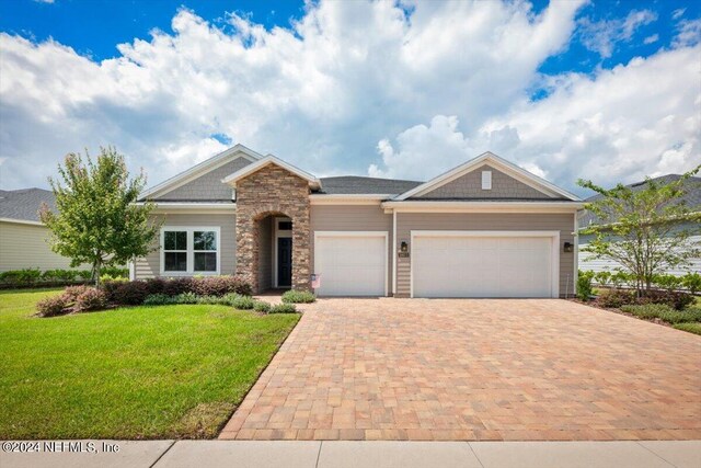 craftsman house with a front lawn and a garage