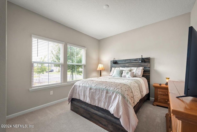 bedroom featuring a textured ceiling and carpet floors