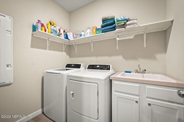 clothes washing area featuring cabinets, hardwood / wood-style floors, sink, and independent washer and dryer