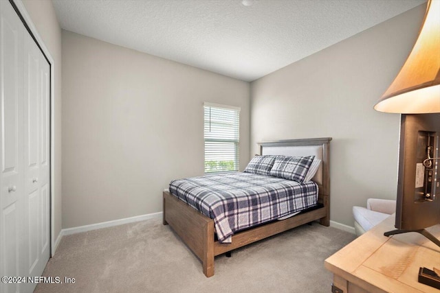 carpeted bedroom with a closet and a textured ceiling