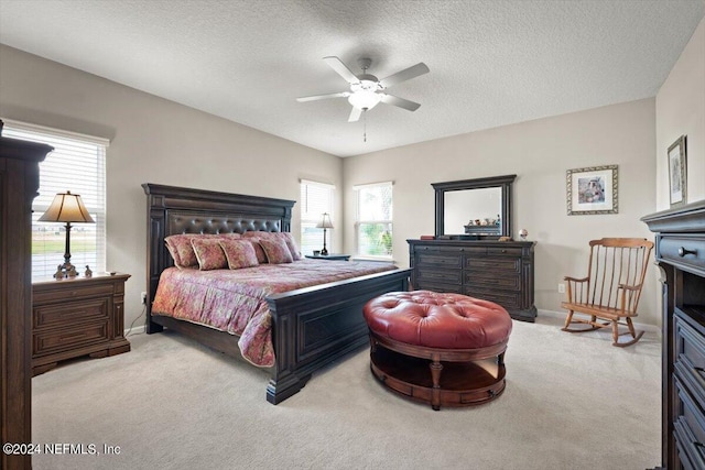 bedroom featuring a textured ceiling, carpet, ceiling fan, and multiple windows