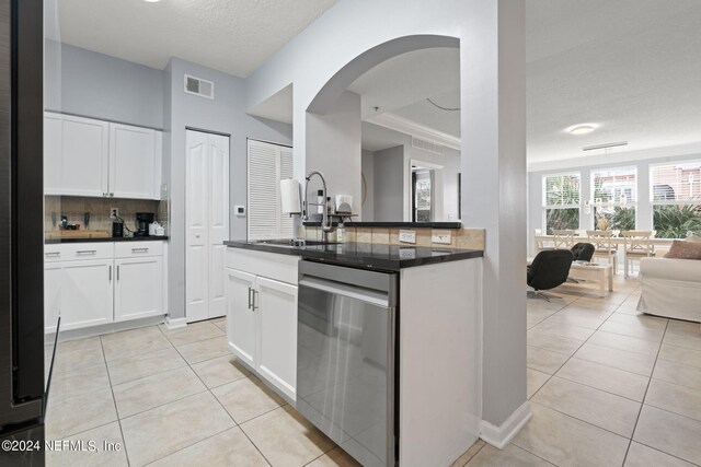 kitchen featuring white cabinets, light tile patterned floors, sink, and stainless steel dishwasher