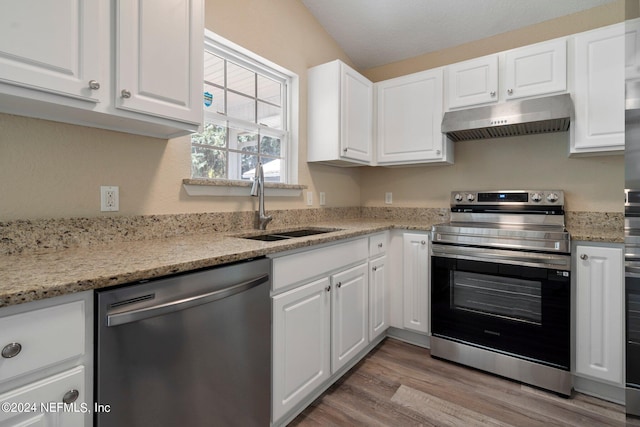 kitchen featuring appliances with stainless steel finishes, light stone counters, light hardwood / wood-style floors, white cabinetry, and sink