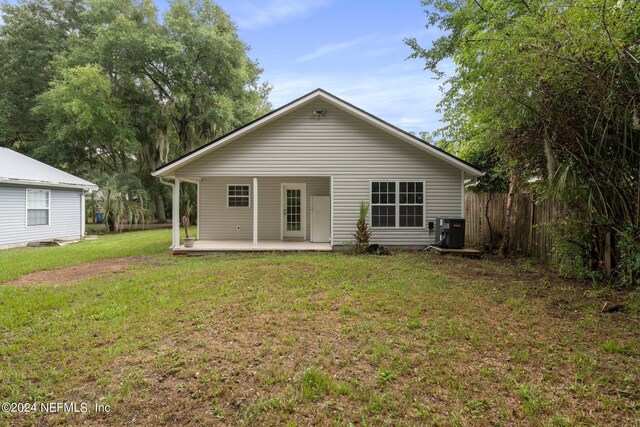 rear view of property with central AC, a yard, and a patio area