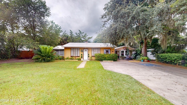 single story home featuring a front lawn