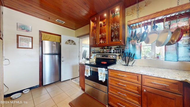 kitchen with appliances with stainless steel finishes, light stone counters, tasteful backsplash, light tile patterned floors, and wooden ceiling